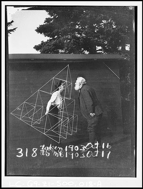 Alexander Graham Bell facing his wife, Mabel Hubbard Gardiner Bell, who is standing in a tetrahedral kite, Baddeck, Nova Scotia (Library of Congress)