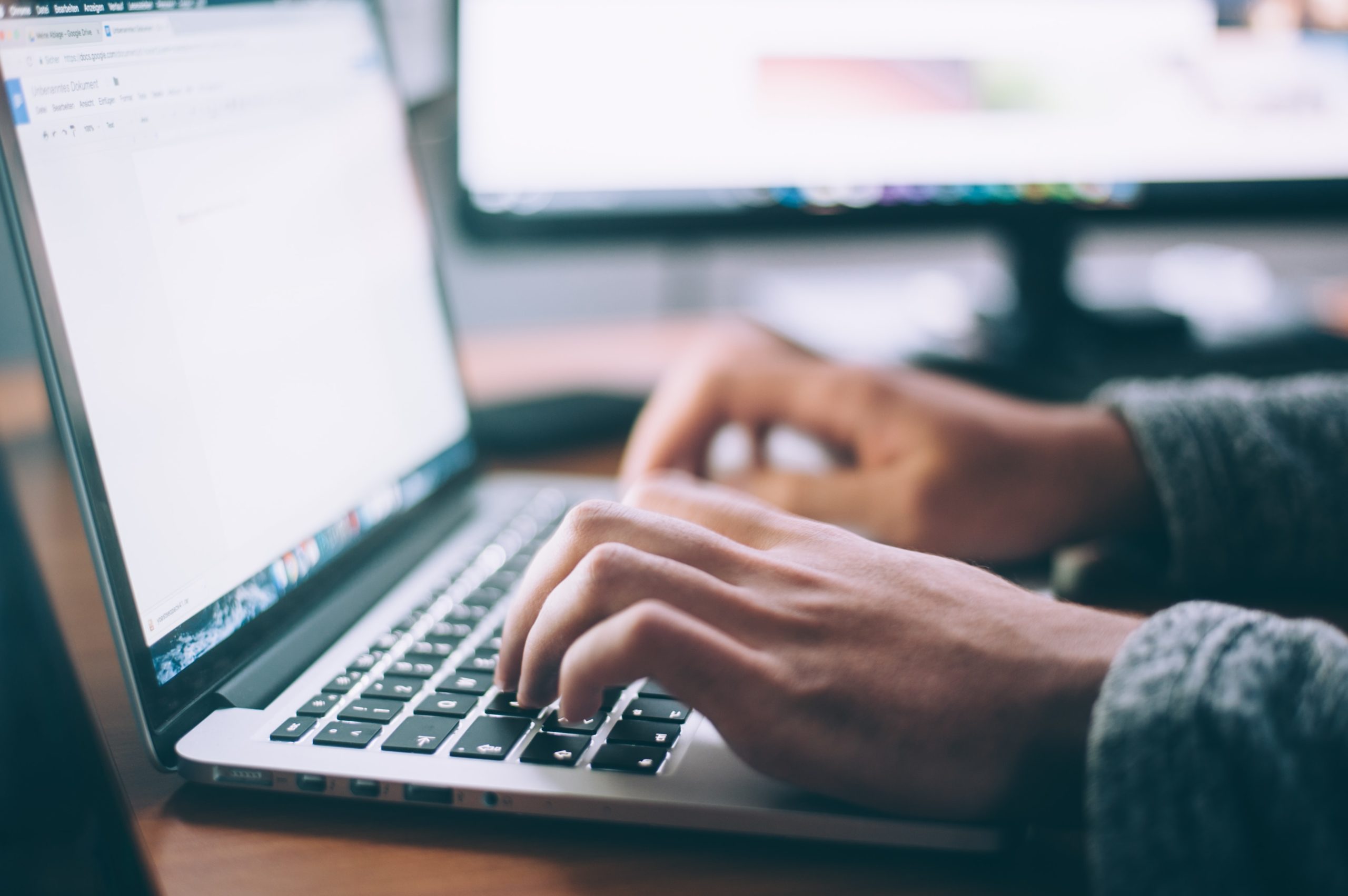 hands typing on a laptop