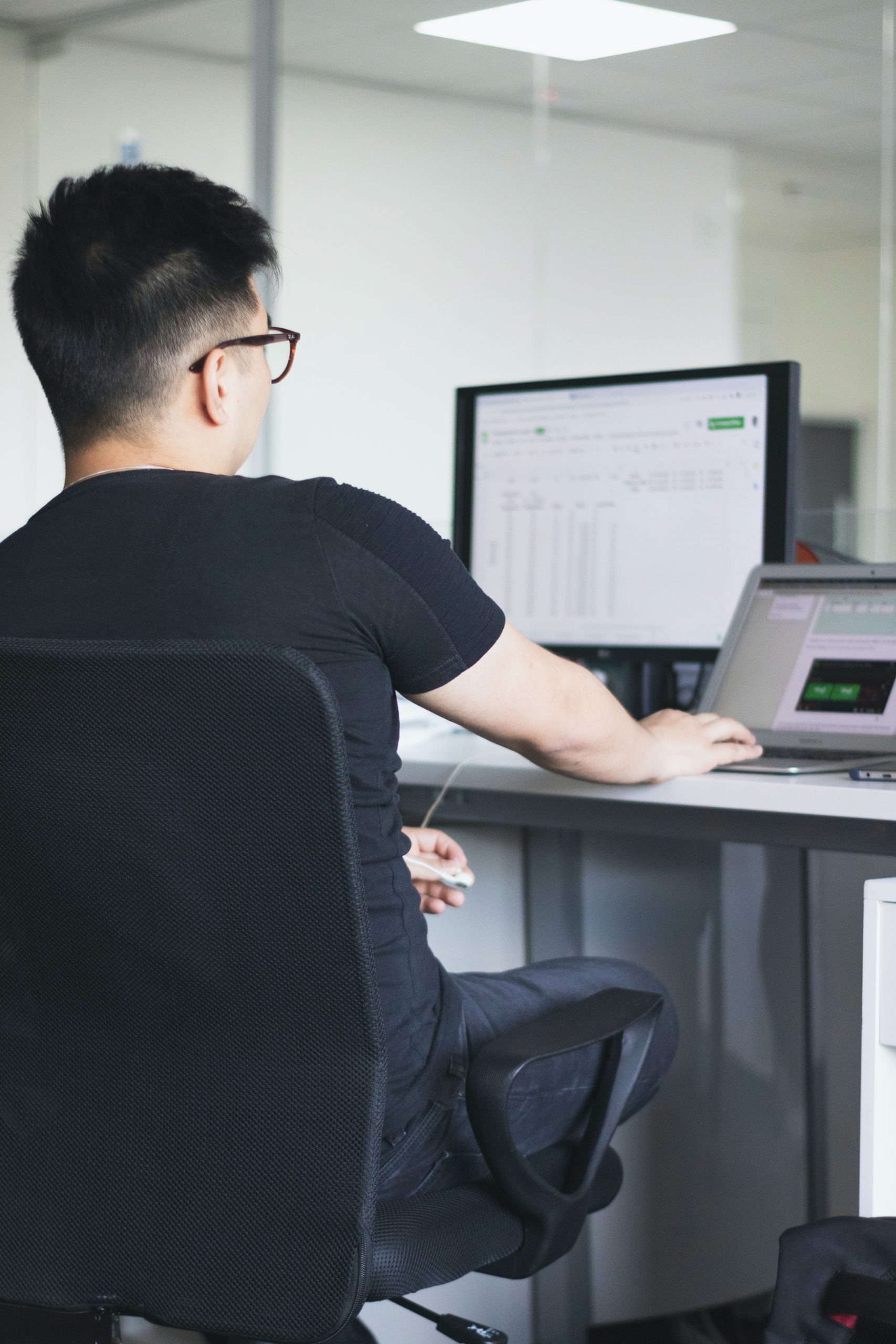 man working on his computer at a desk