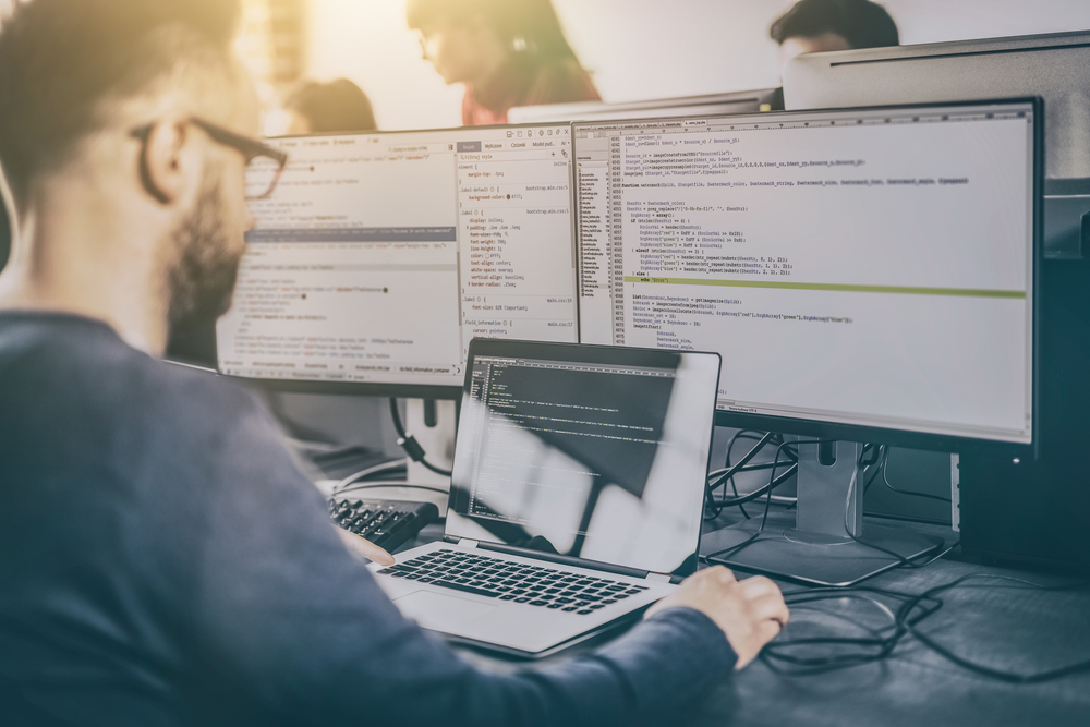 man using multiple computers to work