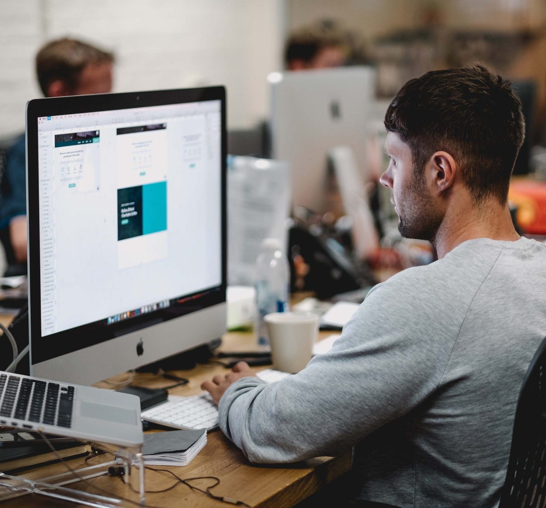 man working on mac monitor in office