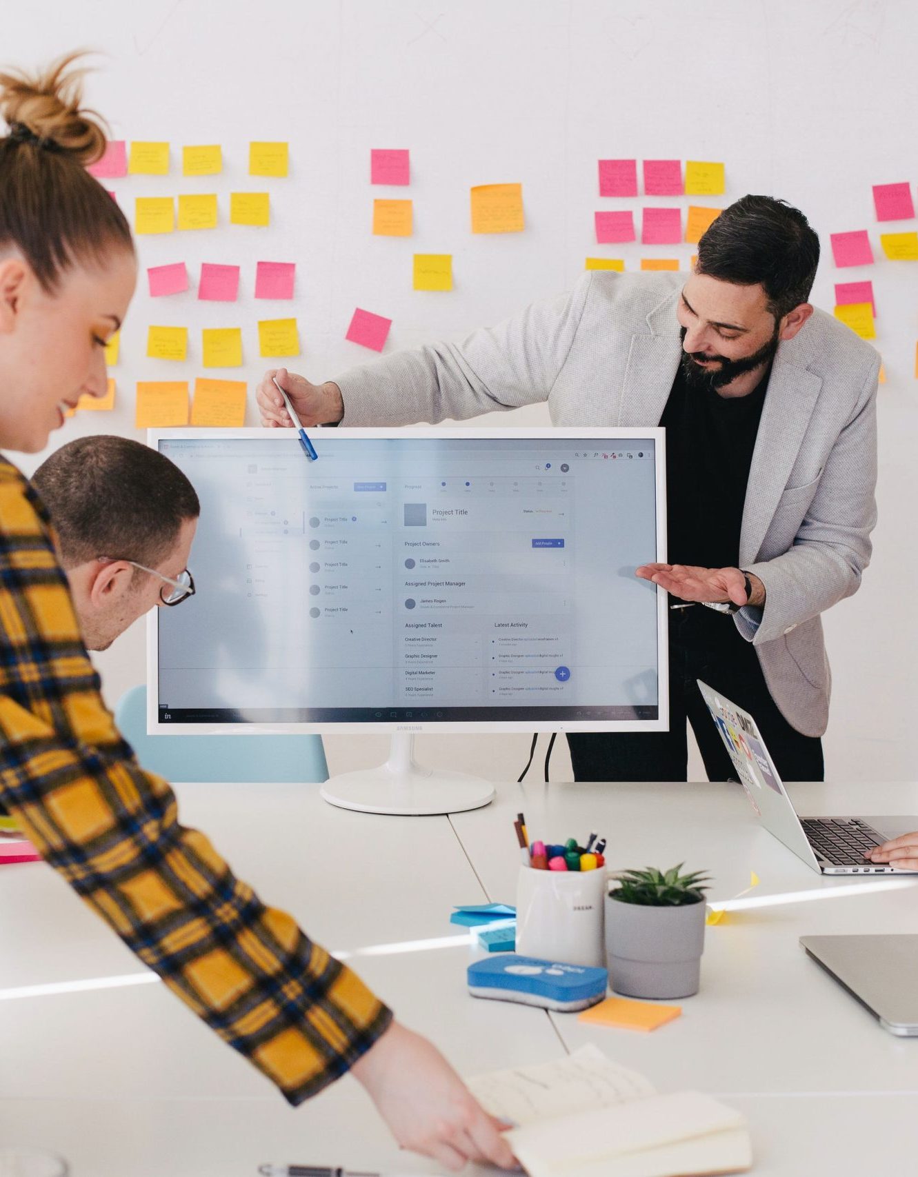 coworkers using large monitor at table